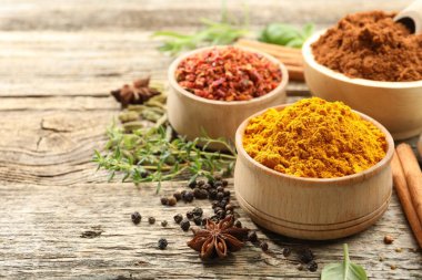 Ahşap masada farklı aromatik baharatlar, yakın plan. Metin için boşluk