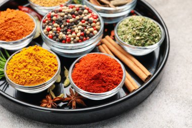 Açık gri masada farklı aromatik baharatlar, yakın plan.