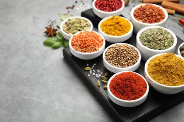 Gri masada farklı aromatik baharatlar, yakın plan. Metin için boşluk