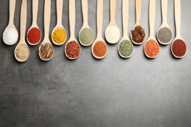Gri masadaki kaşıklarda bir sürü farklı baharat var. Metin için boşluk
