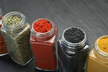 Siyah masadaki kavanozlardaki farklı aromatik baharatlar.