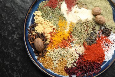 Koyu dokulu masa üzerinde farklı aromatik baharatlar, üst görünüm