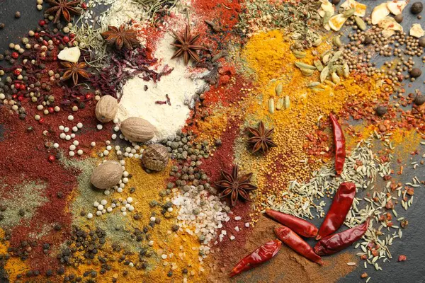 Gri masada farklı aromatik baharatlar, üst görünüm.