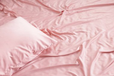 Güzel pembe ipek çarşaflar yatağın üstünde, manzaranın üstünde.