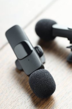 Lavalier mikrofonları ahşap masada, yakın plan. Ses ekipmanları