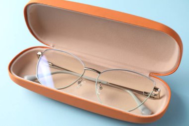 Açık mavi arka planda şık gözlüklü çanta, yakın plan