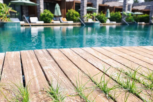 Tatil köyünde ahşap güverteli açık havuz.