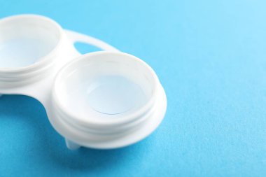 Açık mavi arka planda kontak lensler, yakın plan. Metin için boşluk