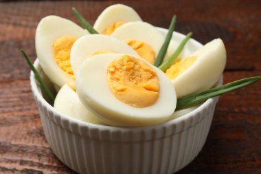 Haşlanmış yumurta ve yeşil soğan ahşap masada, yakın plan.