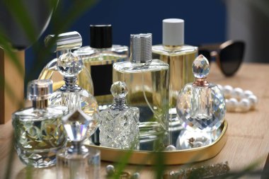 İçerideki ahşap masada parfüm şişeleri.