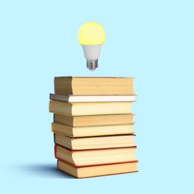 Havadaki ampul, pastel mavi arka plan üzerine yığılmış bir yığın kitabın üzerinde. Fikir ve bilgi