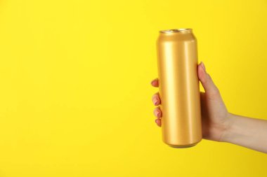 Sarı arka planda teneke kutusu olan kadın, yakın plan. Metin için boşluk