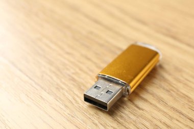 Tahta arka planda bir flaş bellek, yakın plan. Metin için boşluk