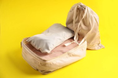 Sarı arka planda giysileri olan küpler paketleniyor