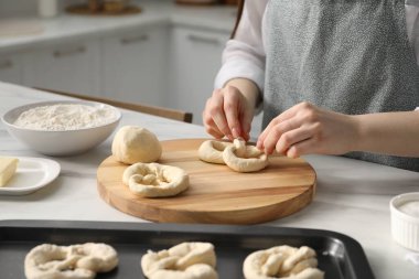 Mutfaktaki masada simit şekillendiren kadın, yakın plan.