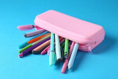 Açık mavi arkaplan üzerindeki kalemler ve kalemler, yakın plan