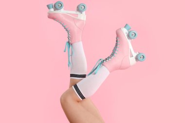 Pembe arka planda paten giyen kadın, yakın plan.