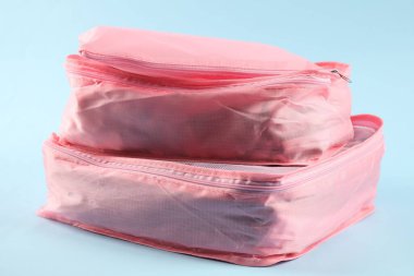 Açık mavi arkaplanda giysileri olan küpler paketleniyor, yakın plan