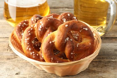 Sepette lezzetli krakerler ve ahşap masada bir bardak bira, yakın plan.