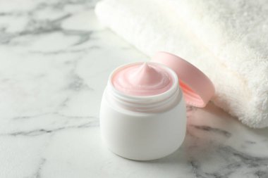 Beyaz mermer masanın üzerinde bir kavanoz nemlendirici vücut kremi, yakın plan. Metin için boşluk