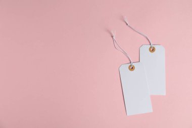 Pembe arka planda ipleri olan boş etiketler, düz yatış. Metin için boşluk