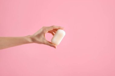 Açık pembe arka planda sabun çubuğu olan kadın, yakın plan. Metin için boşluk