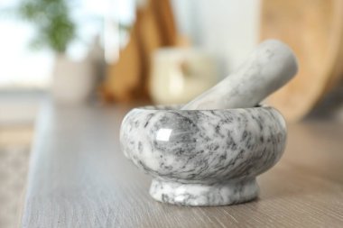 Mutfaktaki ahşap masada mermer harç ve tokmak, yakın plan. Metin için boşluk