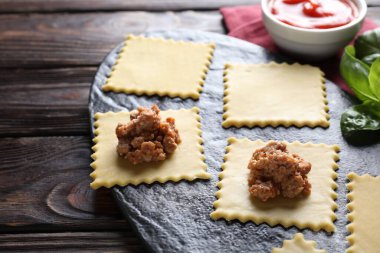Ahşap masada ravioli bolonez yapıyorum, yakın plan.