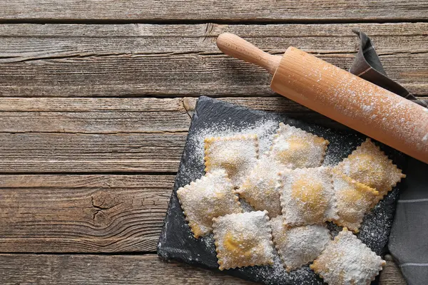 Pişmemiş ravioli ve ahşap masa üzerinde merdane, üst manzara. Metin için boşluk