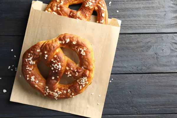 Koyu ahşap masada tuzlu krakerler, üst manzara. Metin için boşluk