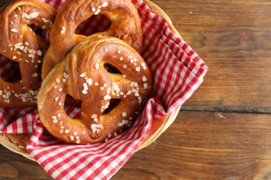 Hasır sepetin içinde tuzlu krakerler, ahşap masa, üst manzara. Metin için boşluk