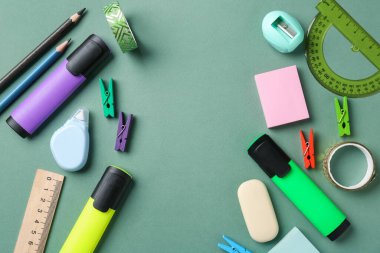 Yeşil arka planda farklı kırtasiye malzemesi, düz. Metin için boşluk