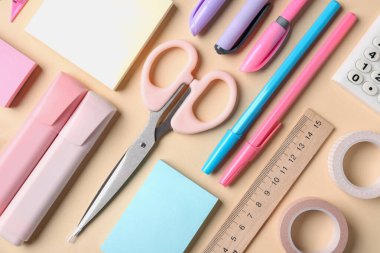 Bej arkaplan üzerine kalemler ve diğer kırtasiyeler, düz yatıyordu