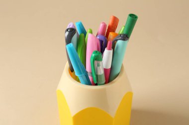 Kalemler ve kalemler bej arka planda, yakın plan