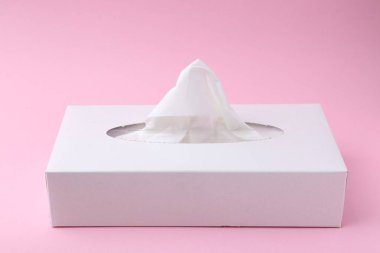 Pembe arka planda kağıt mendilli kutu, yakın plan.