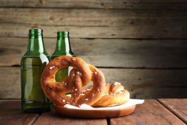 Lezzetli krakerler ve bira şişeleri ahşap masada, yakın plan.