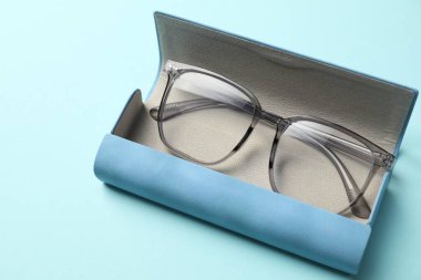 Açık mavi arka planda şık gözlüklü çanta, yakın plan