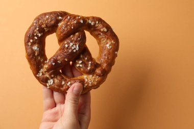 Turuncu arka planda lezzetli krakerli kadın, yakın plan. Metin için boşluk