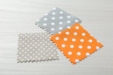 Beyaz ahşap masadaki farklı kumaşlardan örnekler, yakın plan.