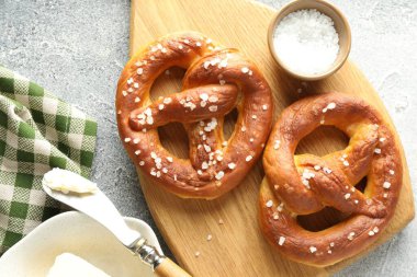 Tuz ve tereyağlı lezzetli krakerler açık gri masada, düz yerde.