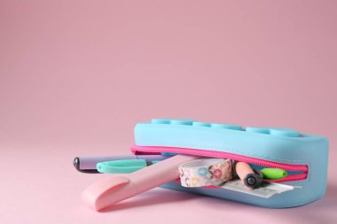 Pembe arka planda kalem kutusunda farklı bir kırtasiye, yakın plan. Metin için boşluk