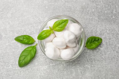 Mozzarella peynirli toplar ve fesleğen açık gri masa, üst manzara