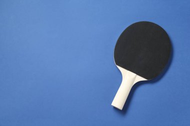 Mavi arka planda bir pinpon raketi, üst manzara. Metin için boşluk