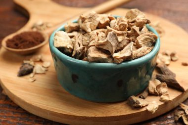 Kuru hindiba kökleri kasede ve kaşıkta, masada toz, yakın plan.