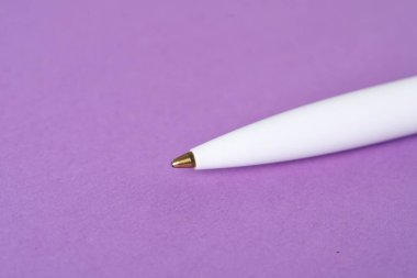 Mor arka planda şık bir kalem, makro görünüm. Metin için boşluk