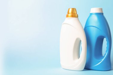 Açık mavi arkaplanda yumuşatıcı şişeler, metin için boşluk