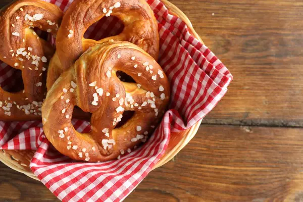Hasır sepetin içinde tuzlu krakerler, ahşap masa, üst manzara. Metin için boşluk