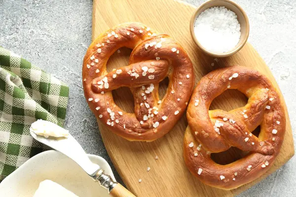 Tuz ve tereyağlı lezzetli krakerler açık gri masada, düz yerde.