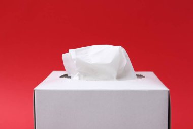 Kırmızı arkaplanda kağıt mendilli kutu, yakın plan