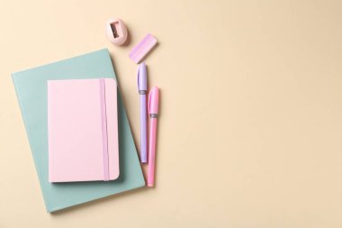 Kalemler ve bej arka plandaki diğer kırtasiyeler düz. Metin için boşluk